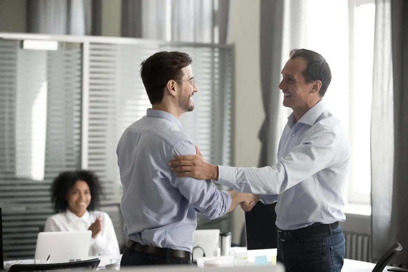 Two colleagues shaking hands in an office
