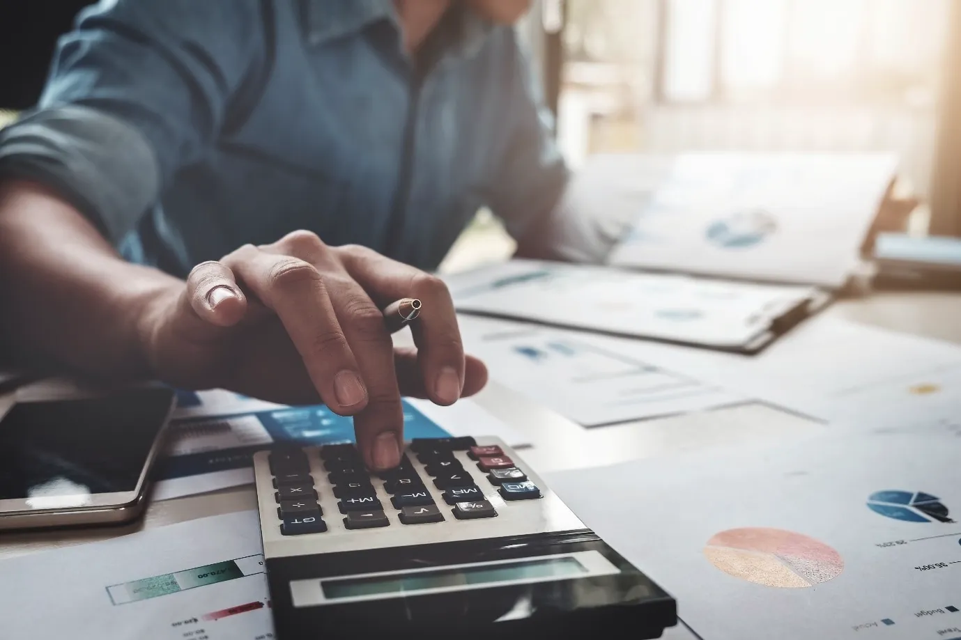 A calculator and financial reports on a desk