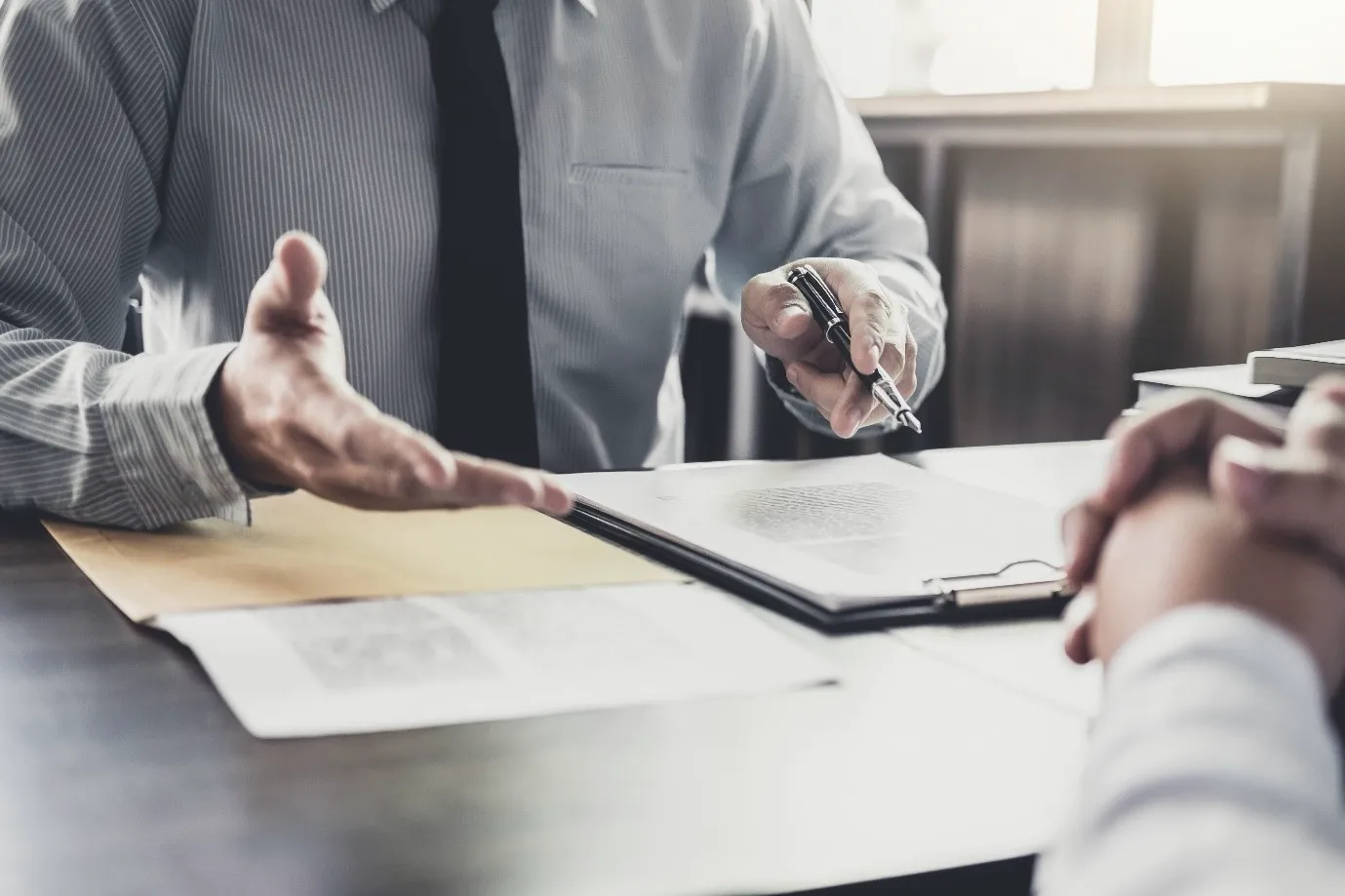 A solicitor talking a client through paperwork across a desk