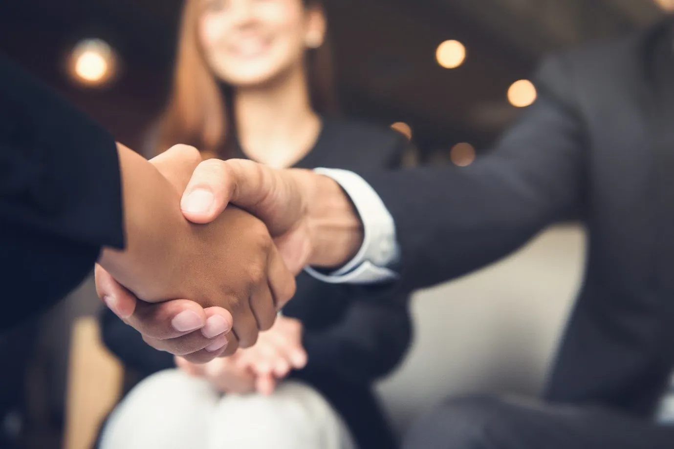 Two people shaking hands and smiling