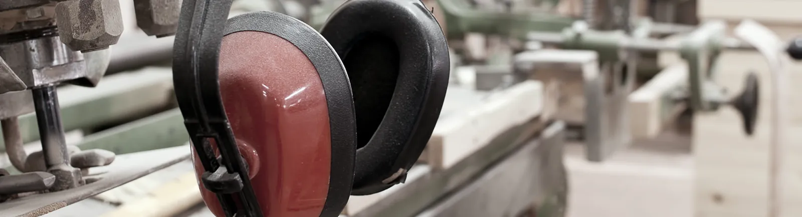 Ear defenders resting on a workbench in a workshop