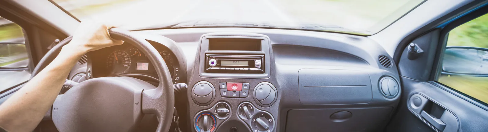 A driver's hands on the steering wheel of a car