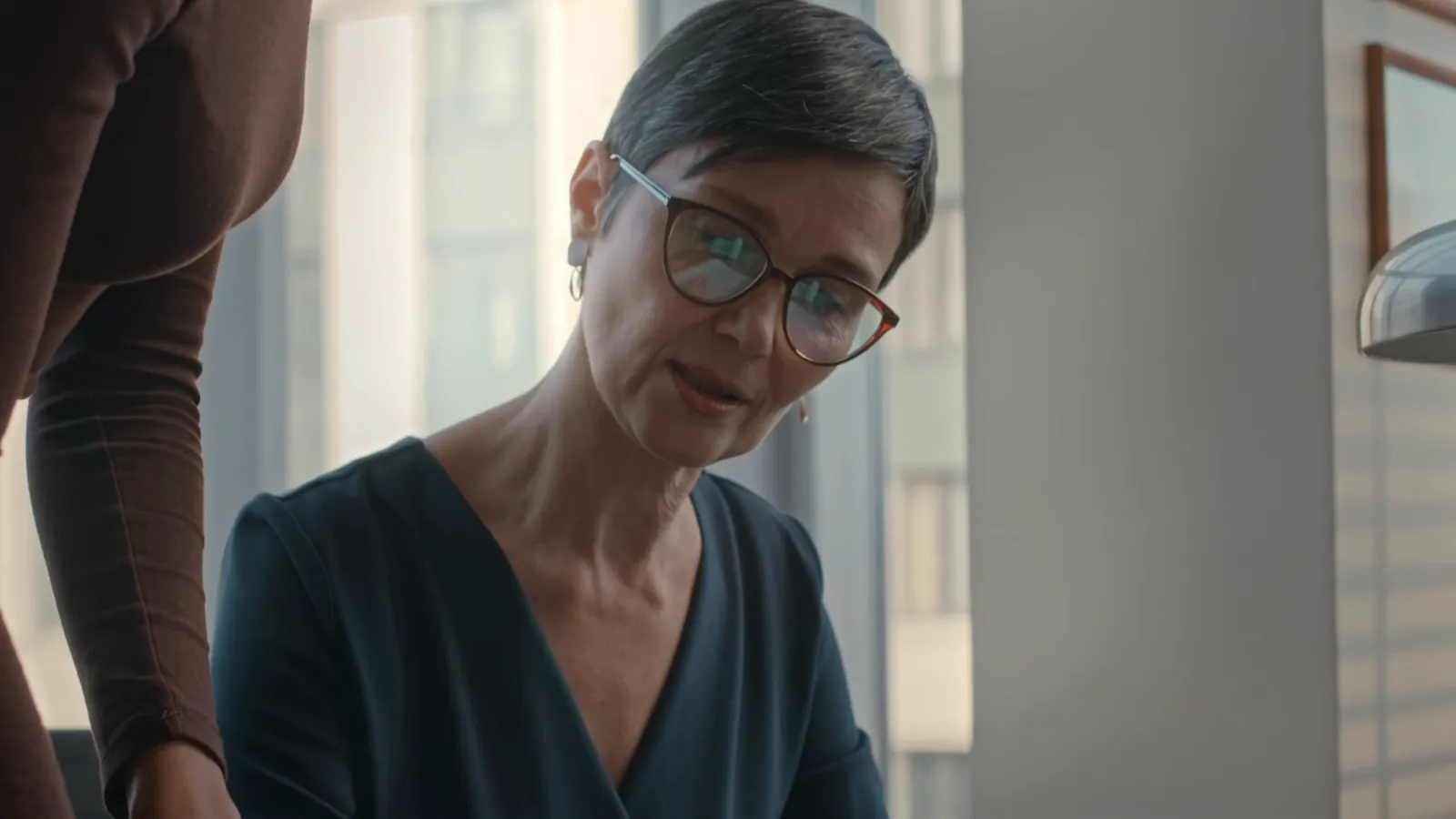 A solicitor listening to a client in a bright office